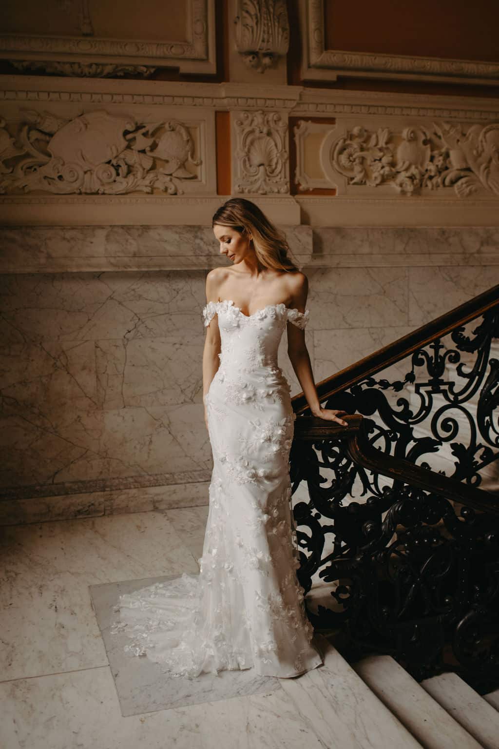 Dreamy Suzanne Neville Debussy wedding gown has a corseted cupped bodice with off the shoulder floral straps and a fitted skirt in our pretty Debussy floral tulle. Find your wedding dress at Your Dream Bridal in near Boston.